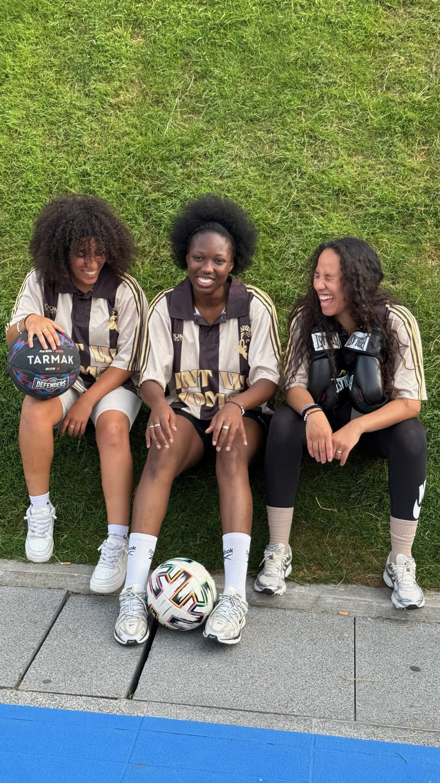 Trois femmes en maillots AWW avec ballon de football et gants de boxe